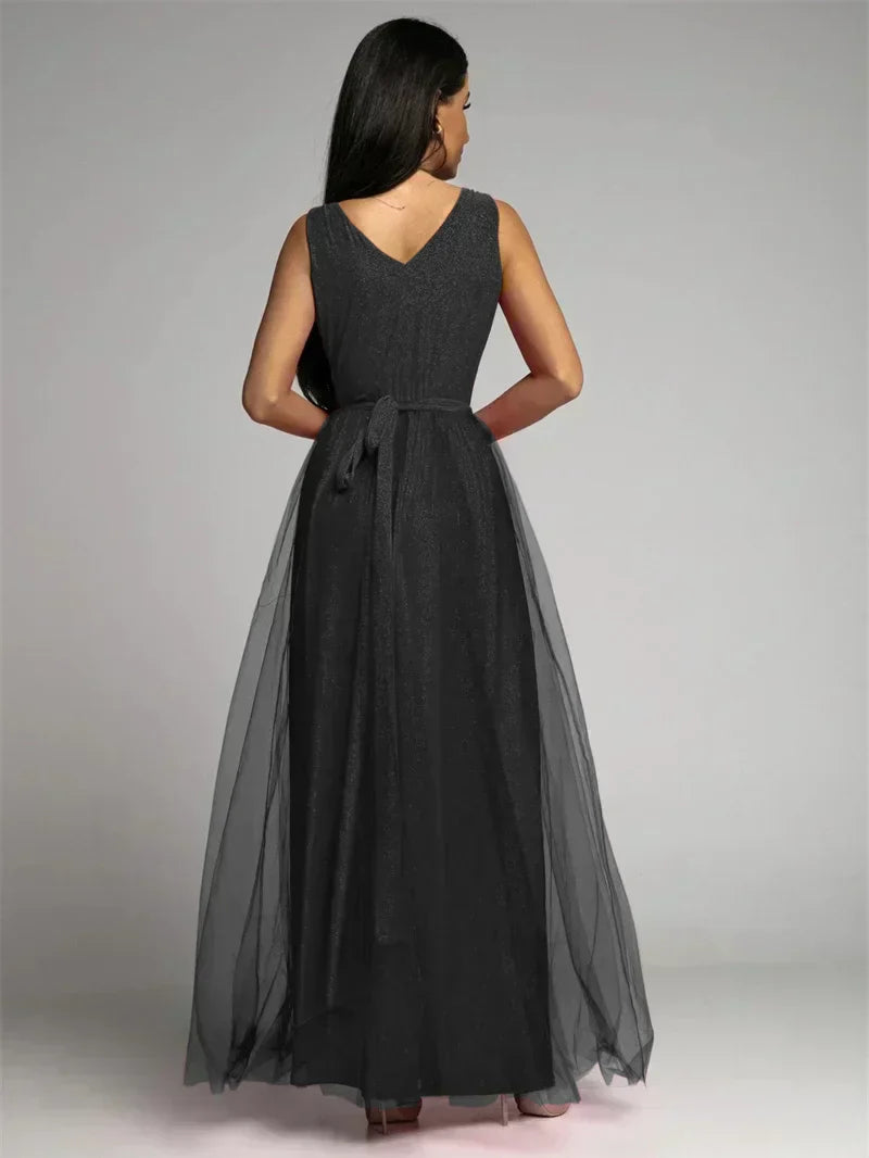 Robe de soirée longue noire élégante, dos en V, ceinture nouée, jupe en tulle transparent, mode féminine chic, tenue de gala sophistiquée.