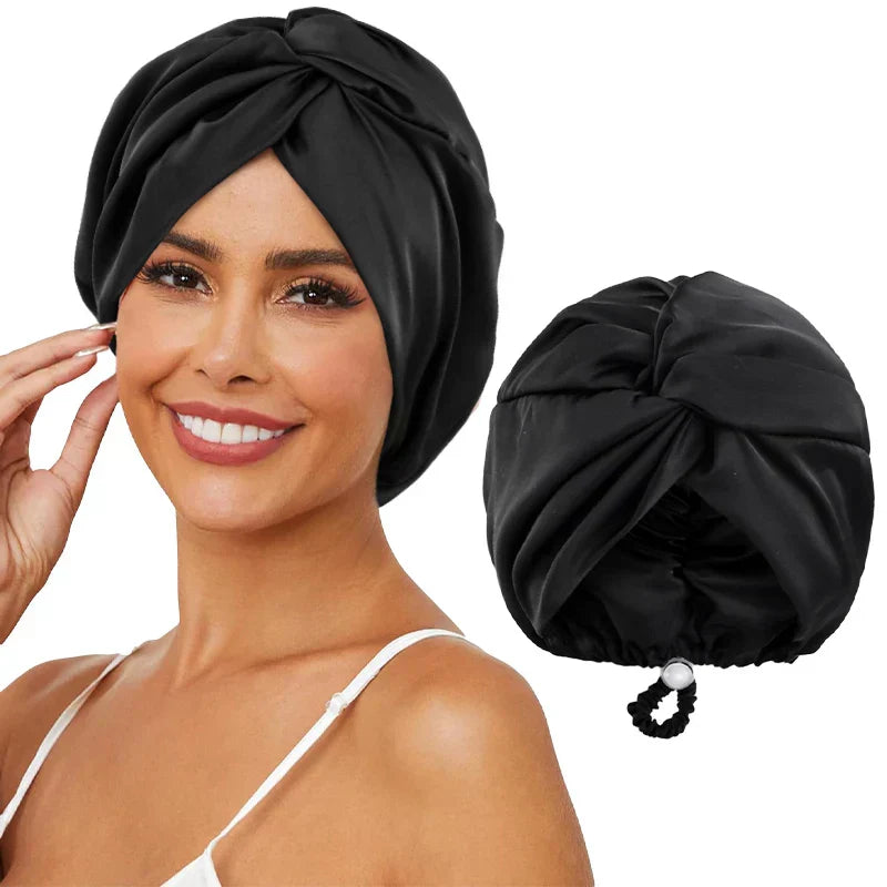 Femme souriante portant un turban en satin noir, accessoire de mode élégant pour cheveux, avec un turban similaire à côté.