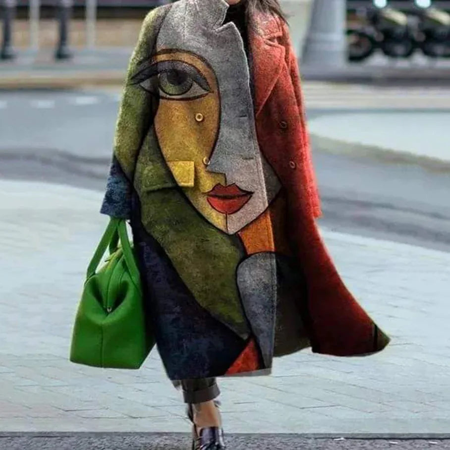 Manteau artistique coloré avec motif visage cubiste, femme tenant un sac vert vif, mode urbaine moderne, rue pavée en arrière-plan.