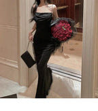 Femme en robe noire élégante tenant un bouquet de roses rouges, sortant d'un ascenseur. Mode soirée, glamour, chic, accessoires de luxe.