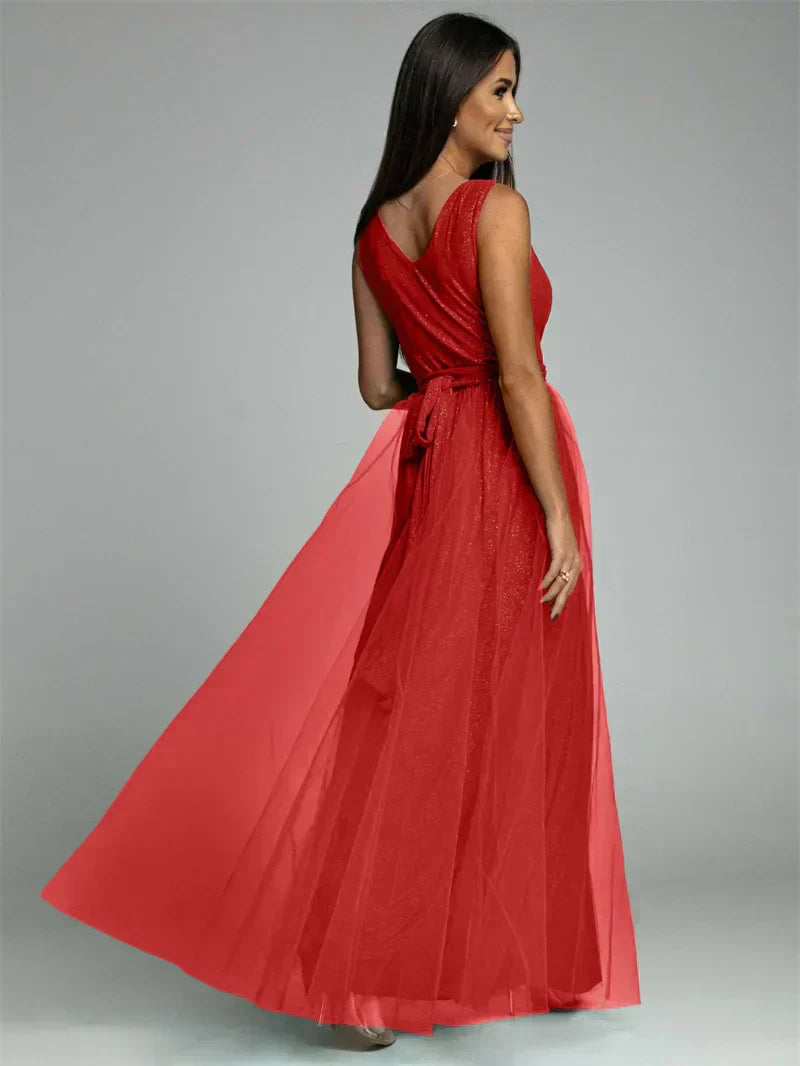 Femme en robe longue rouge élégante, dos nu, avec ceinture nouée, posant de profil. Mode féminine, tenue de soirée chic, style glamour.