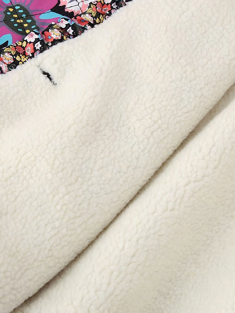 Veste en polaire blanche avec motif floral coloré, texture douce et chaude, idéale pour l'hiver. Mode femme, tendance et confort.