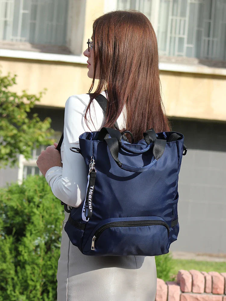 Femme portant un sac à dos bleu élégant en plein air, devant un bâtiment. Sac à dos mode, pratique pour le quotidien et les voyages urbains.