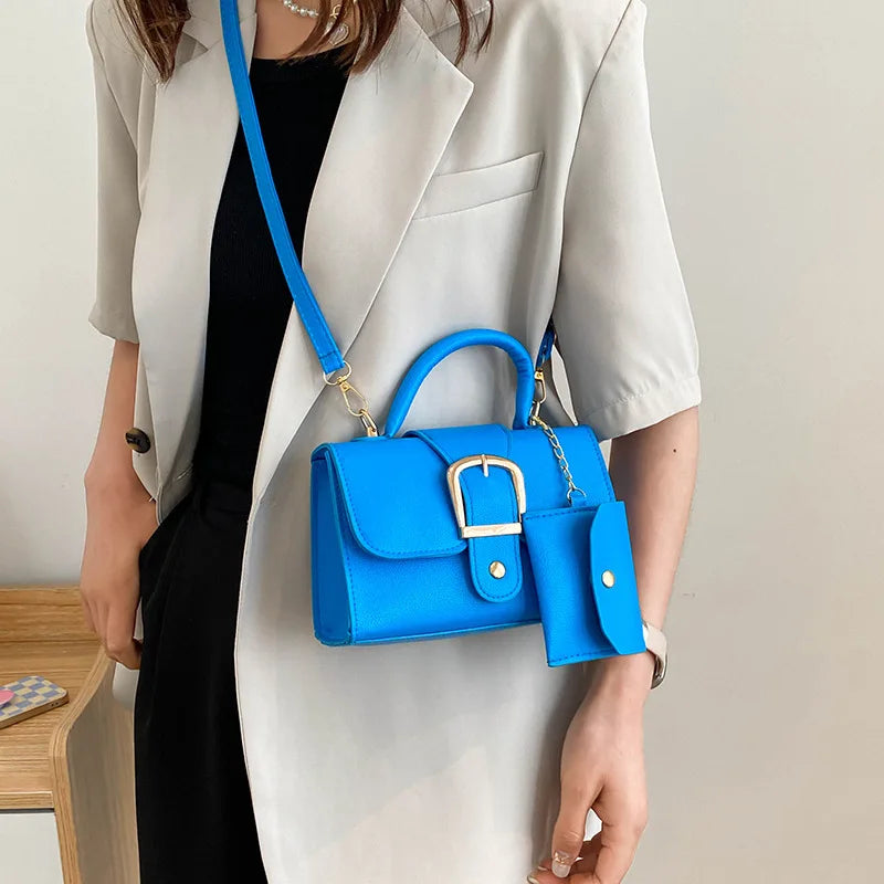 Sac à main bleu vif avec boucle dorée, porté par une femme en blazer beige. Accessoire de mode élégant et tendance, idéal pour un look chic.