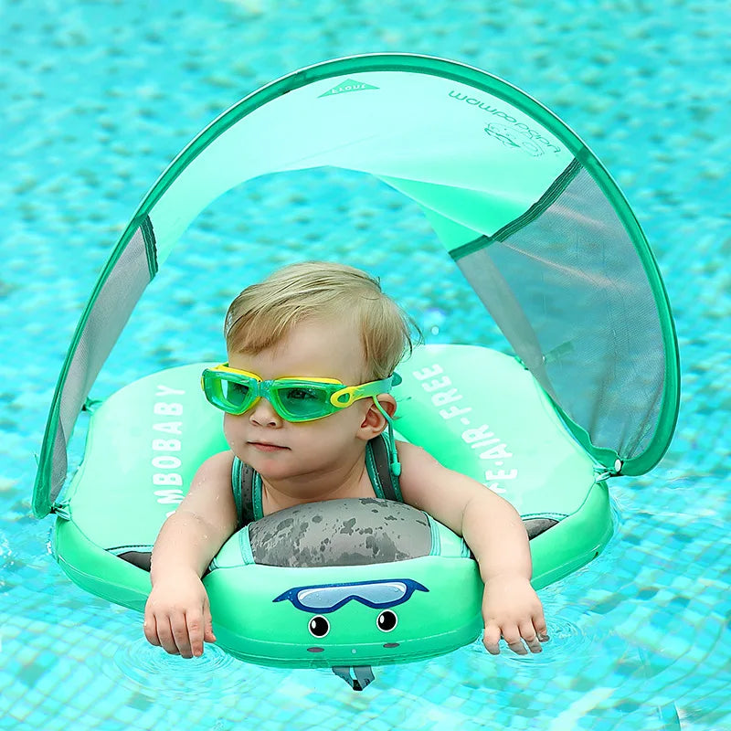 Bébé avec lunettes de soleil vertes sur bouée verte avec auvent dans piscine. Flotteur bébé, sécurité piscine, été, baignade enfant.