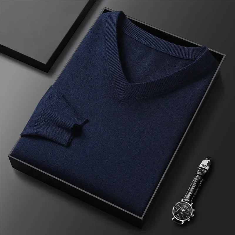 Pull-over bleu marine en cachemire plié dans une boîte noire, accompagné d'une montre-bracelet élégante. Mode homme, vêtements de luxe.