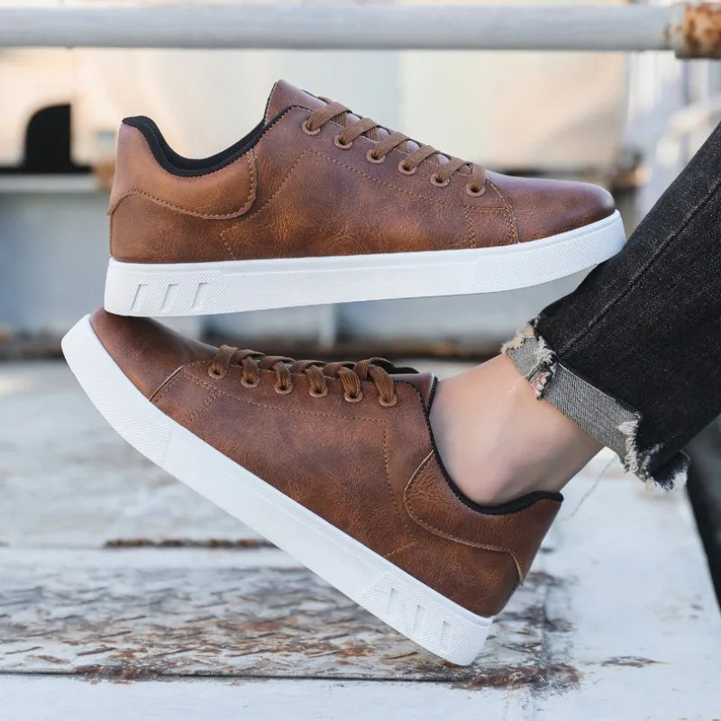 Chaussures en cuir marron pour homme avec semelle blanche, style décontracté, posées sur une surface en bois. Mode masculine, sneakers tendance.
