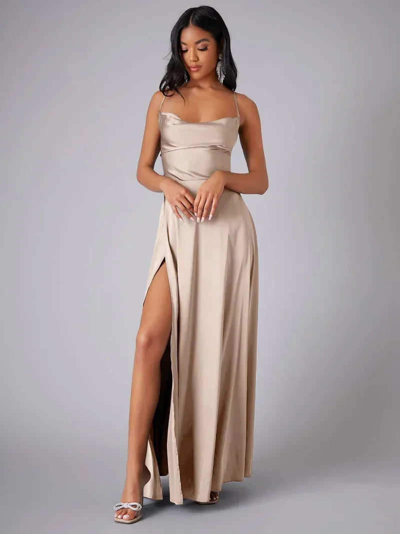 Femme portant une robe longue satinée beige avec fente haute, posant élégamment. Mode féminine, robe de soirée chic, tendance 2023.