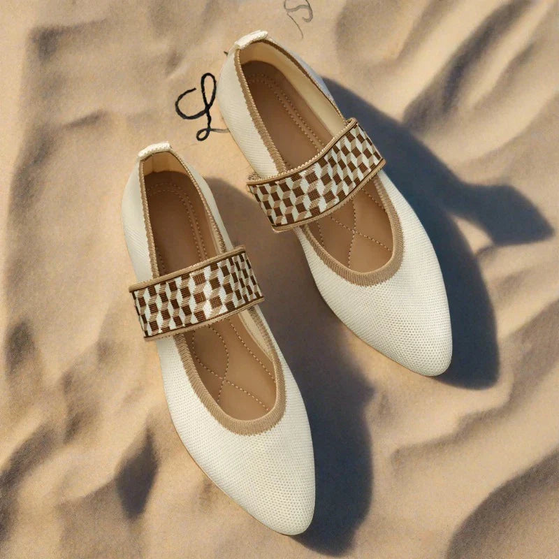 Ballerines blanches élégantes avec bride tressée marron sur fond de sable. Chaussures femme tendance, confortables et stylées pour l'été.