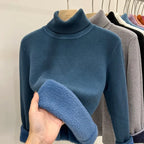 Pull bleu col roulé en laine, exposé sur un cintre avec d'autres pulls de différentes couleurs en arrière-plan. Mode hiver, vêtements chauds.