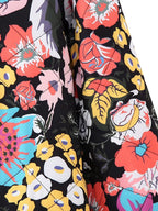 Veste matelassée à motifs floraux colorés sur fond noir, avec des fleurs rouges, jaunes et bleues. Mode tendance, style bohème chic.