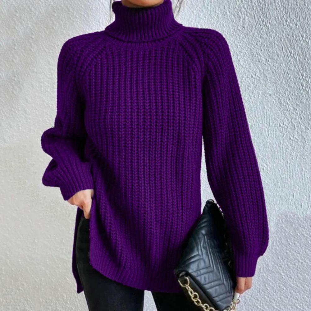 Pull violet à col roulé en maille épaisse, porté avec un sac à main noir matelassé à chaîne dorée, sur fond de mur texturé blanc.