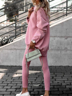 Femme en tenue décontractée rose, portant un sac à main vert pastel, posant sur des marches en béton. Mode urbaine, style confortable, tendance.