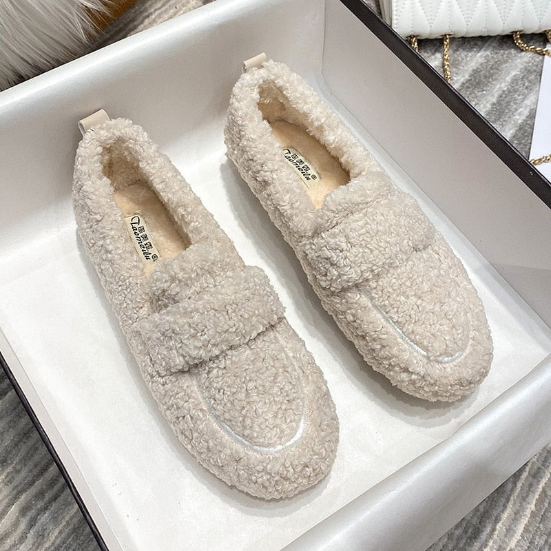 Chaussures mocassins en peluche beige pour femme dans une boîte, confortables et élégantes, idéales pour l'hiver. Mode féminine, tendance automne-hiver.