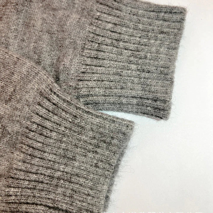 Manche de pull en laine grise, texture côtelée, gros plan. Mode hiver, vêtement chaud, tricot doux, style décontracté, tendance automne-hiver.