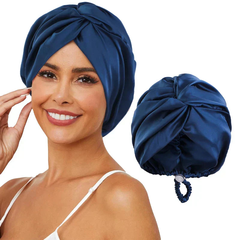 Femme souriante portant un turban en satin bleu foncé, accessoire de mode élégant pour cheveux, avec un turban similaire à côté.