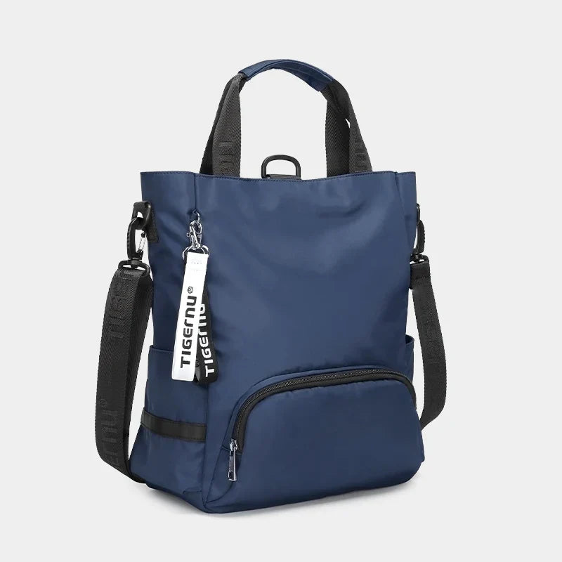 Sac à dos bleu Tigernu en nylon, design moderne, avec poignées noires et poche avant zippée. Idéal pour le voyage et le quotidien.