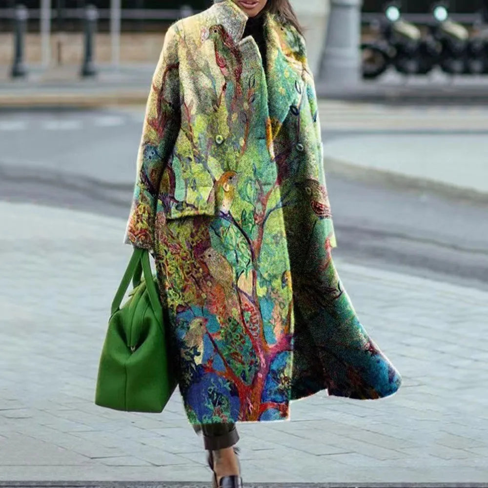 Manteau coloré avec motifs artistiques porté par une femme, accompagné d'un sac vert vif, sur fond urbain. Mode automne-hiver, style unique.