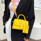 Sac à main jaune vif avec bandoulière, porté par une personne en blazer noir. Accessoire tendance, mode féminine, design moderne et élégant.