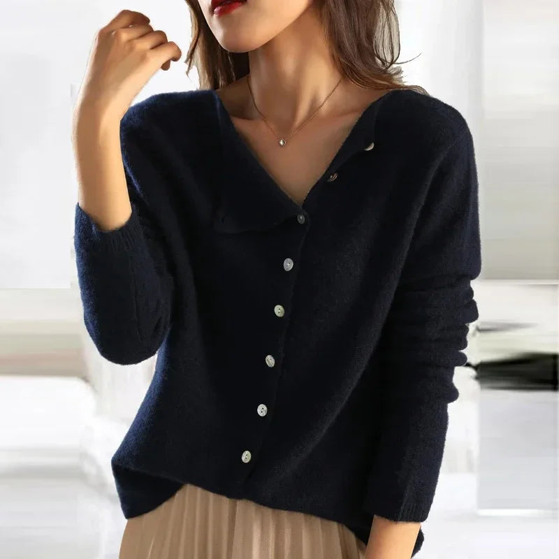 Femme portant un pull en laine bleu marine avec boutons, col en V, manches longues, style élégant et décontracté, mode automne-hiver tendance.