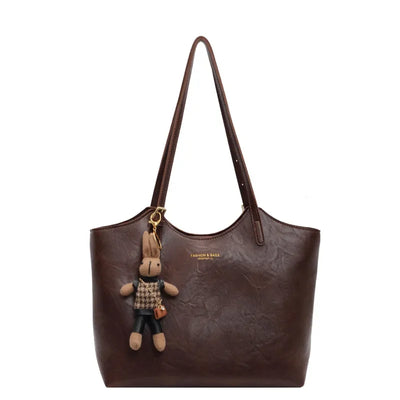 Sac à main en cuir marron avec porte-clés peluche lapin, design élégant, mode femme, accessoire tendance, grande capacité, style chic.