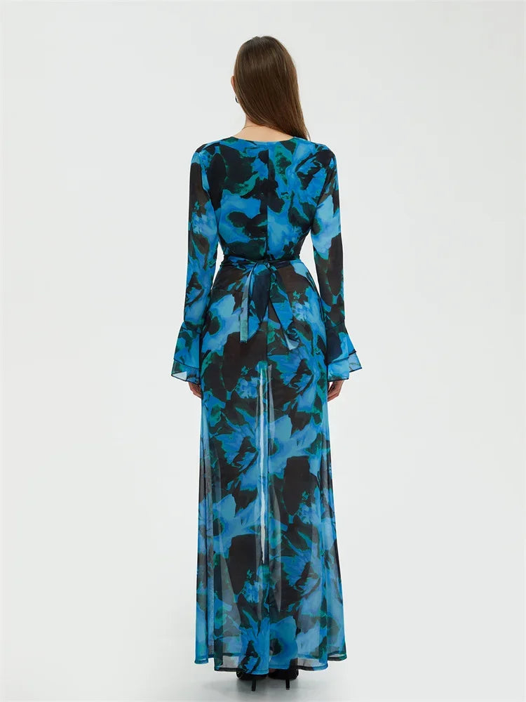 Robe longue bleue à motifs floraux, manches longues, vue de dos. Élégante et moderne, idéale pour soirées ou événements formels.