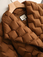 Doudoune marron matelassée sur cintre en bois, étiquette visible. Veste chaude, tendance automne-hiver, style moderne et confortable.