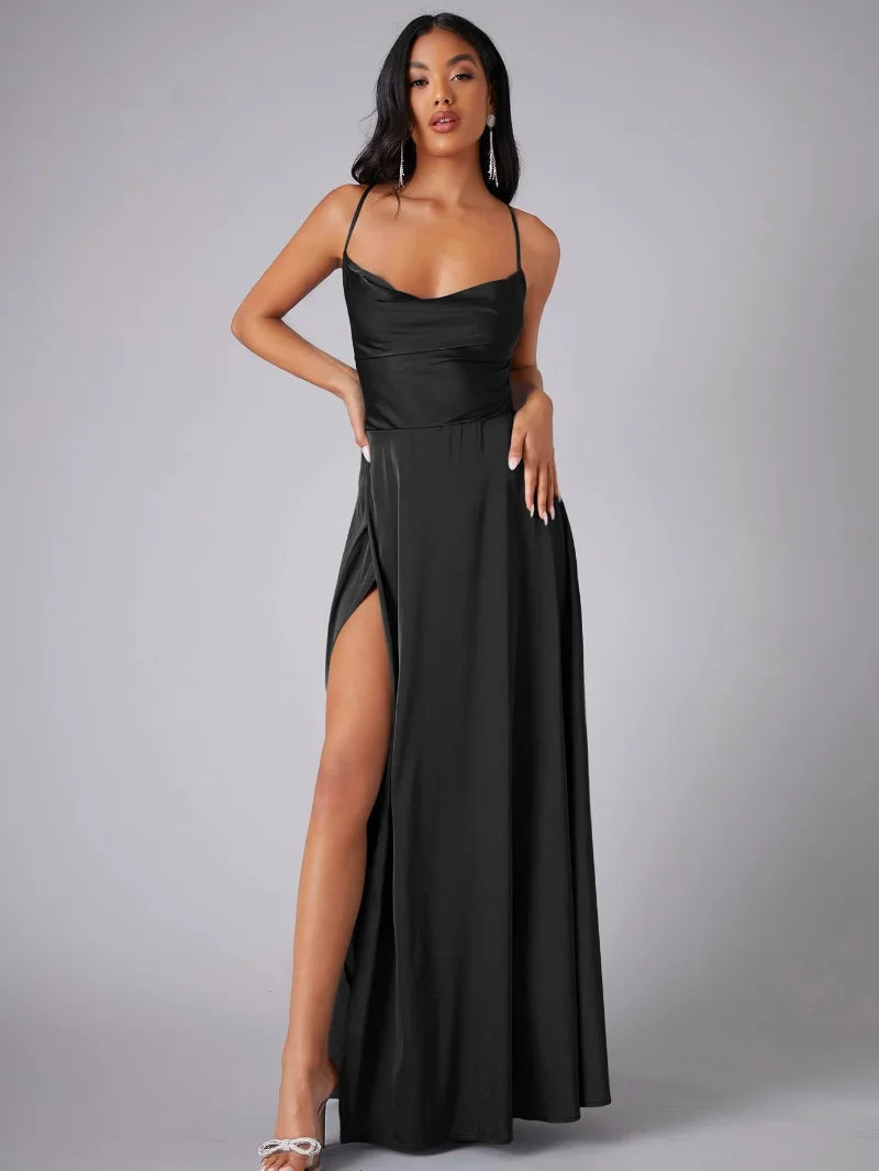 Femme en robe noire élégante avec fente haute, posant sur fond gris. Mode soirée, glamour, style chic, robe longue, tendance 2023.