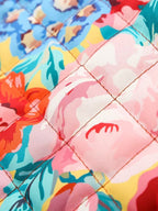 Tissu matelassé à motifs floraux colorés, avec des roses et des fleurs bleues, idéal pour la décoration intérieure et la couture créative.