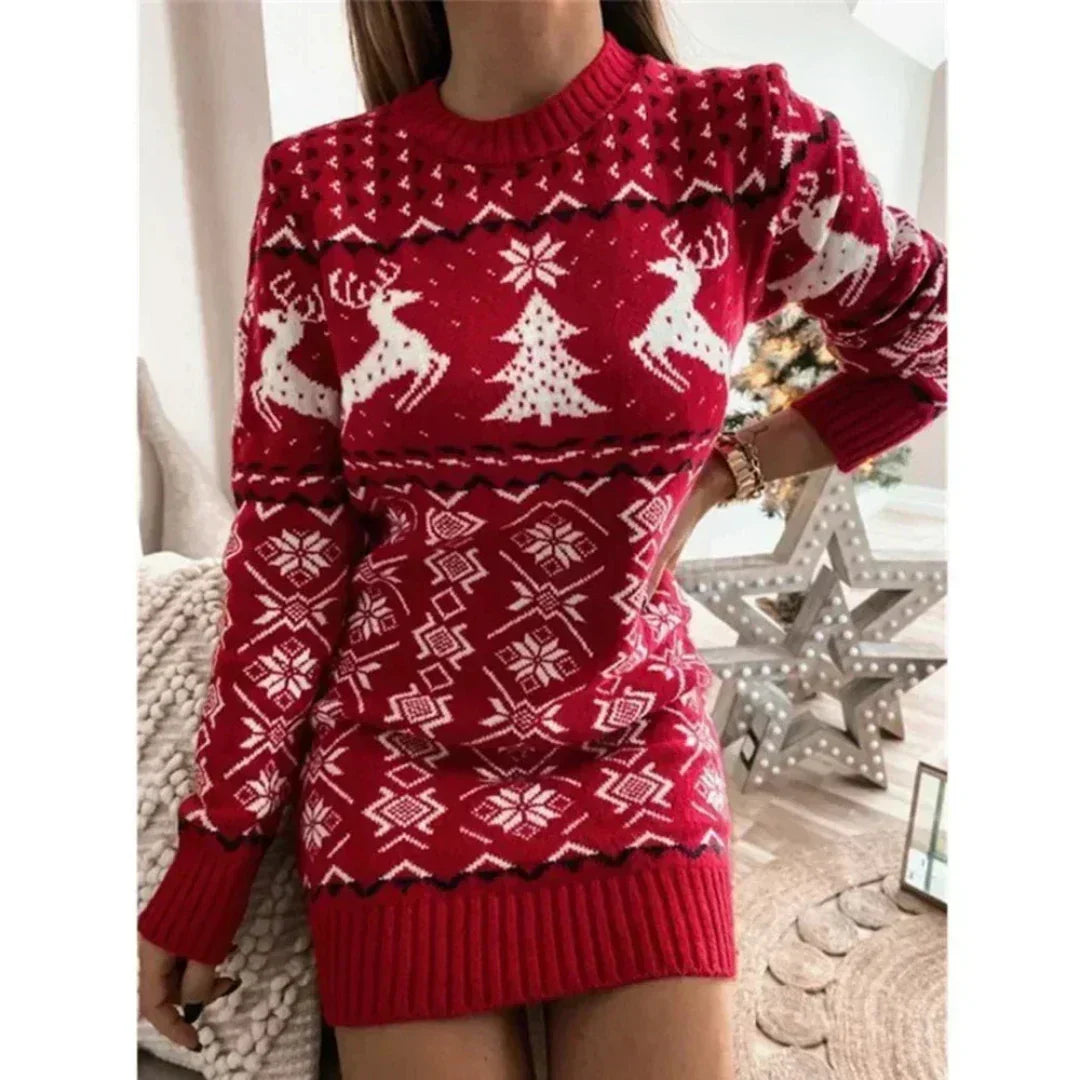 Pull de Noël rouge avec motifs de rennes et sapins blancs, femme posant dans un intérieur moderne. Mode festive, tendance hiver, vêtement chaud.
