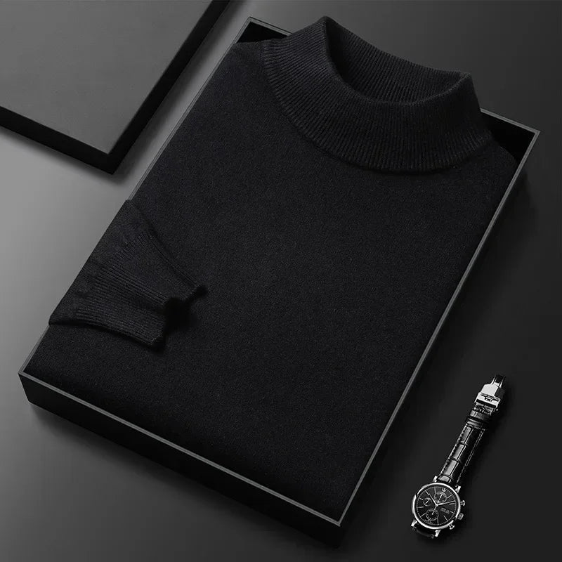 Pull noir en cachemire plié dans une boîte noire, accompagné d'une montre-bracelet élégante. Mode homme, luxe, vêtements d'hiver.