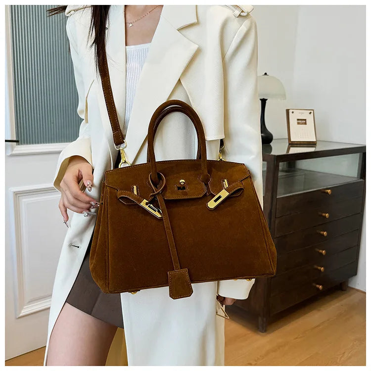 Femme portant un manteau blanc et un sac à main marron élégant, style Birkin, dans un intérieur moderne. Mode féminine, accessoires de luxe.