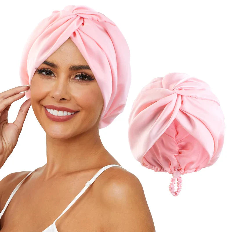 Femme souriante portant un turban en satin rose, accessoire de mode élégant pour cheveux, avec un élastique assorti. Idéal pour soin capillaire.