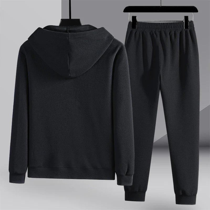 Vêtement de sport noir pour homme, ensemble jogging avec sweat à capuche et pantalon, style décontracté, idéal pour fitness et loisirs.