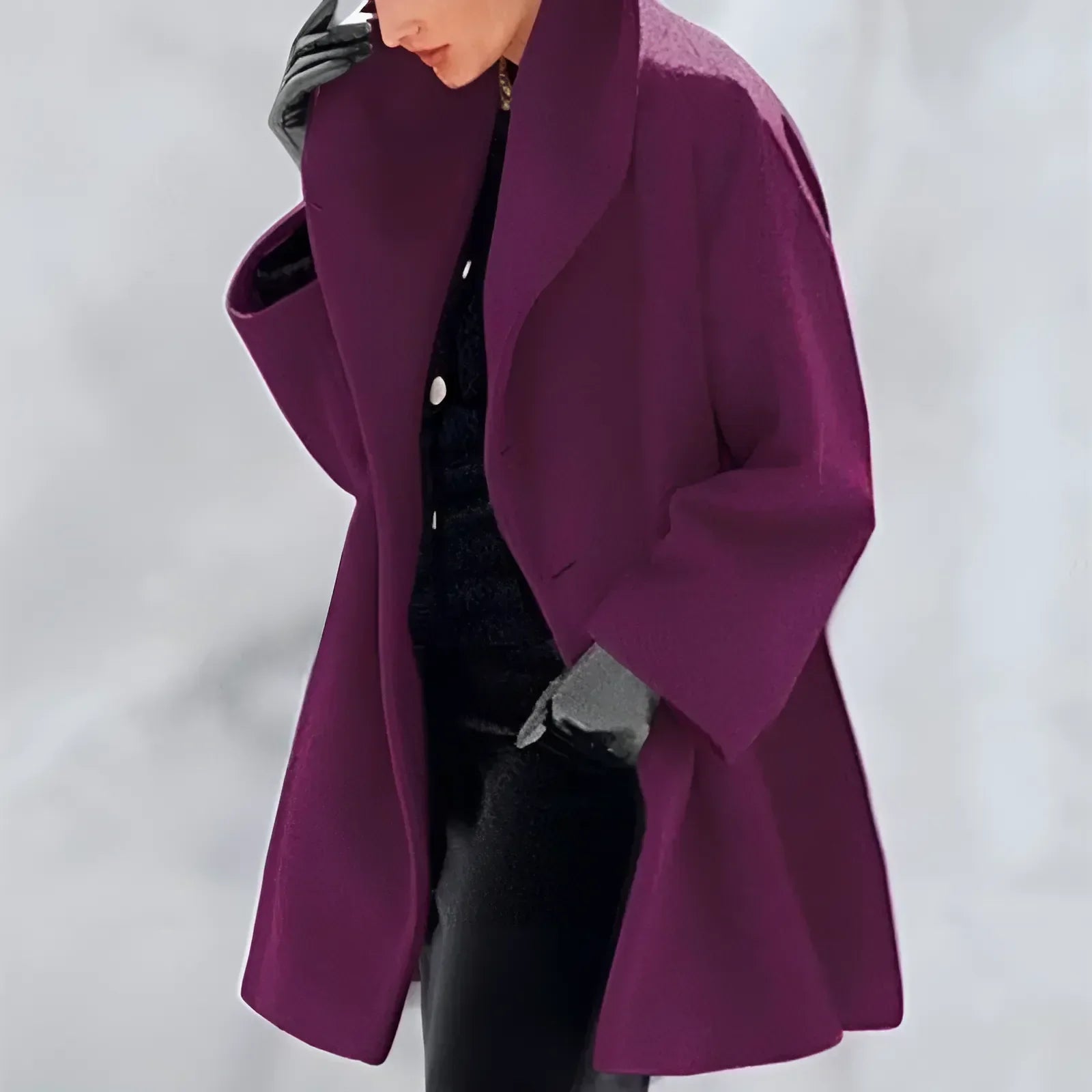 Personne portant un manteau violet élégant, gants noirs, sur fond neutre. Mode hiver, style chic, vêtement tendance.