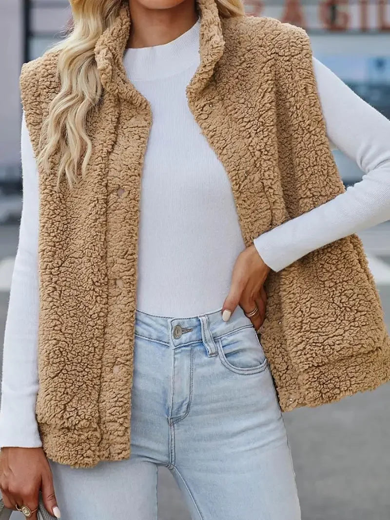 Femme portant un gilet en fausse fourrure beige, manches longues blanches, jean clair. Mode automne, style décontracté, tendance vestimentaire.