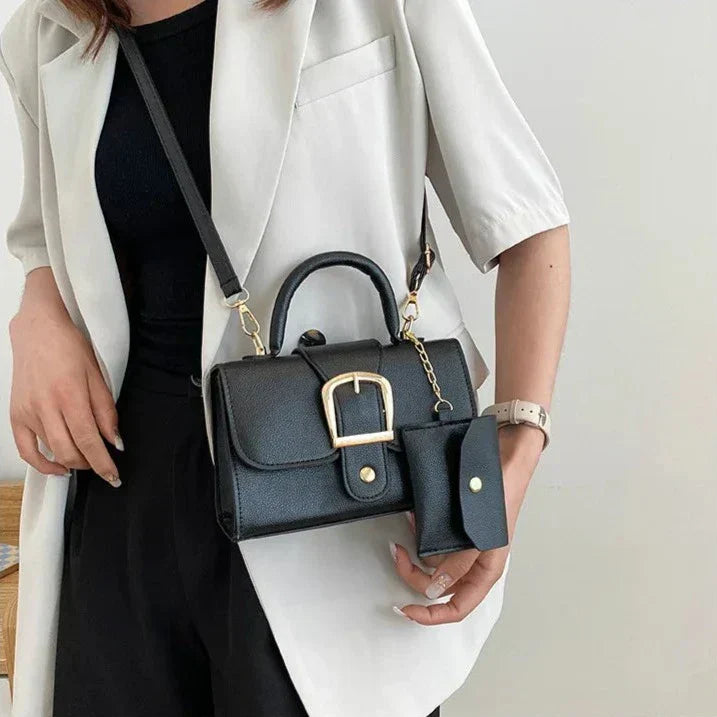 Femme portant un sac à main noir élégant avec boucle dorée, assorti à un étui à clés. Mode chic, accessoires tendance, tenue décontractée.