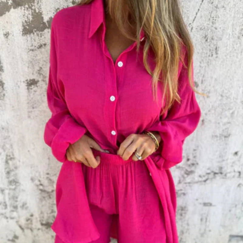 Femme portant une chemise et un short rose vif en lin, posant devant un mur texturé. Mode estivale, tenue décontractée, style tendance.