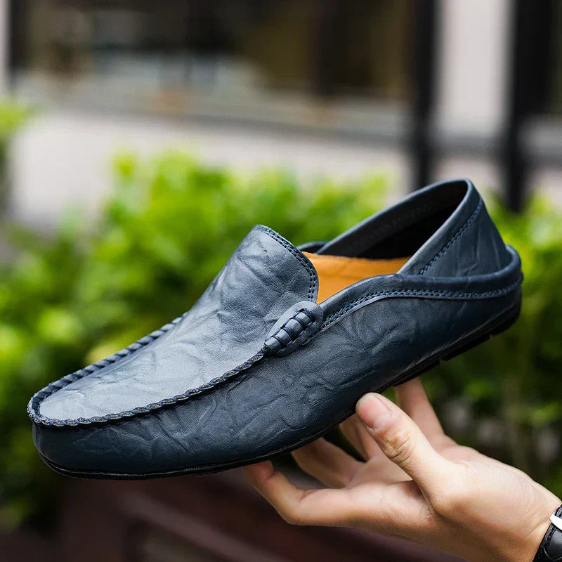 Mocassin en cuir bleu pour homme, élégant et moderne, tenu en main, idéal pour un style décontracté ou formel. Chaussure tendance et confortable.