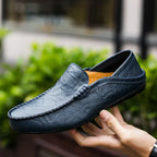 Mocassin en cuir bleu pour homme, élégant et moderne, tenu en main, idéal pour un style décontracté ou formel. Chaussure tendance et confortable.