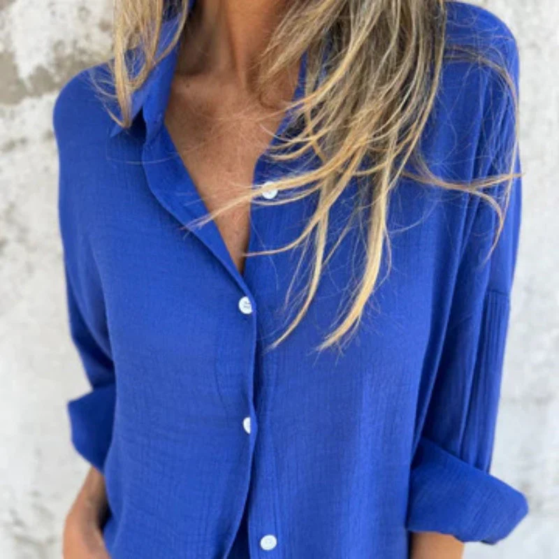 Chemise bleue femme, manches retroussées, tissu léger, col ouvert, boutons blancs, mode décontractée, style estival, tendance actuelle.