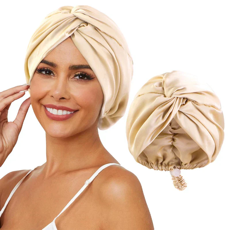 Femme souriante portant un turban en satin beige, accessoire de mode élégant pour cheveux, avec un turban similaire à côté.