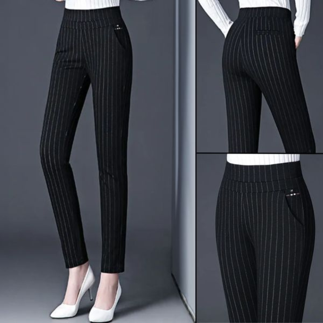 Pantalon noir à rayures verticales pour femme, ajusté et élégant, avec poches latérales, porté avec des talons blancs. Mode féminine chic.