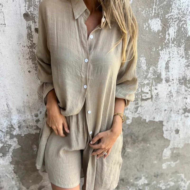 Femme portant une robe chemise beige en lin, manches longues, devant un mur texturé. Mode décontractée, style estival, tenue élégante.