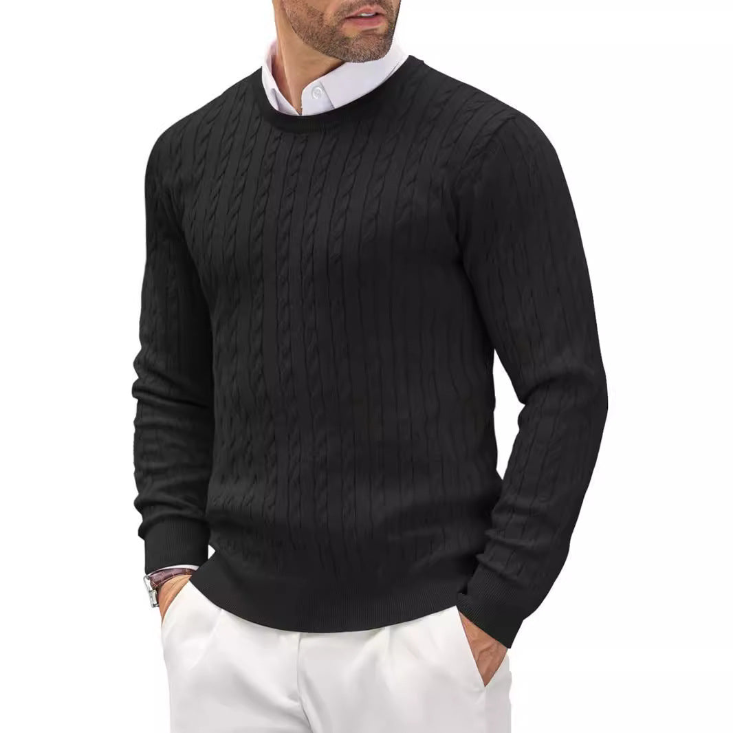 Homme portant un pull noir en maille torsadée, col rond, sur une chemise blanche, style élégant et moderne, mode masculine automne-hiver.