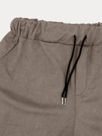 Pantalon de jogging beige en molleton avec cordon de serrage noir, taille élastique, poche latérale. Mode décontractée, confort, style urbain.