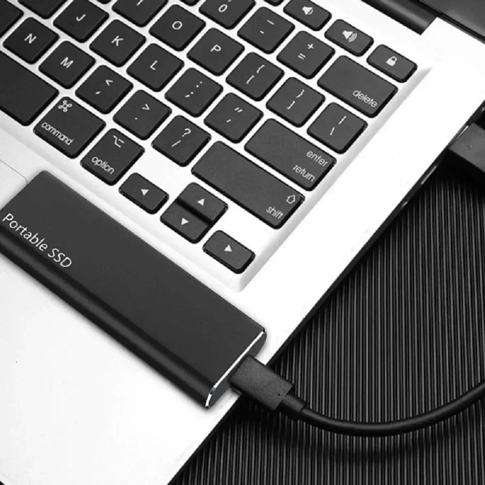 Ordinateur portable avec SSD externe connecté via USB, clavier rétroéclairé, stockage rapide, technologie moderne, accessoire informatique essentiel.