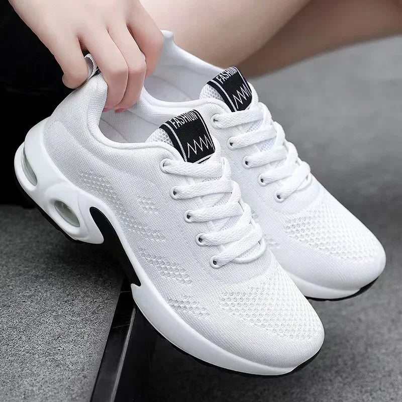Chaussures de sport blanches modernes avec semelle épaisse, design respirant et lacets, idéales pour la course et le fitness.