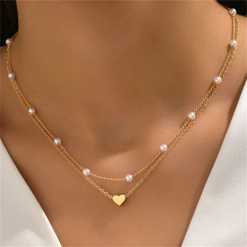 Collier en or à double chaîne avec perles et pendentif cœur, bijou élégant pour femme, accessoire mode tendance, parfait pour occasions spéciales.