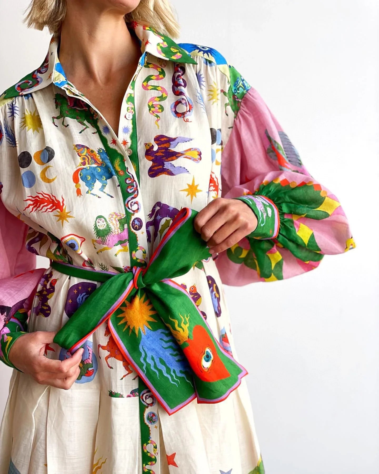 Robe colorée avec motifs astrologiques et ceinture verte, manches roses transparentes. Mode bohème chic, tendance et originale.